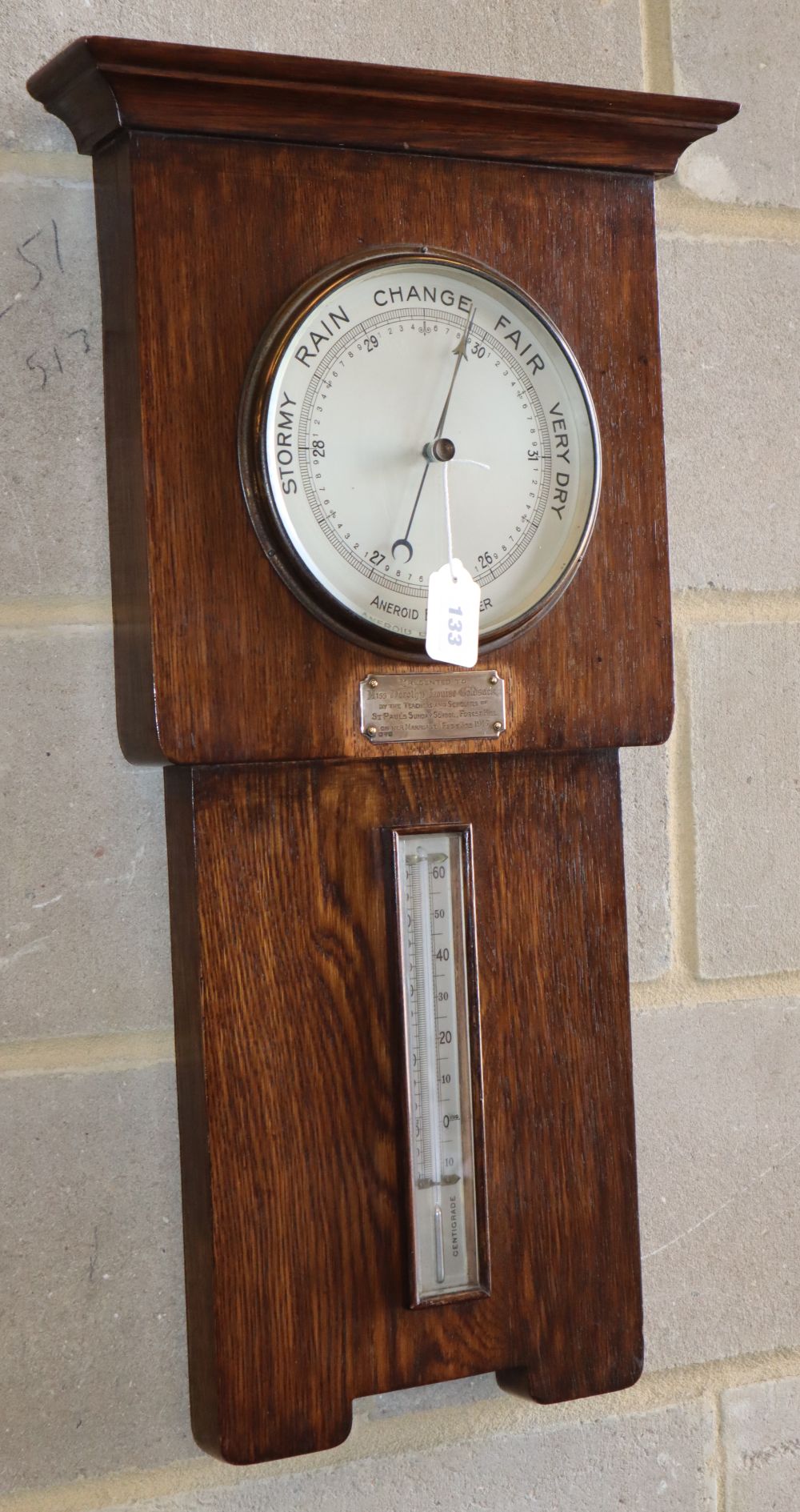 An oak aneroid barometer / thermometer, dated 1915, W.38cm, H.71cm.